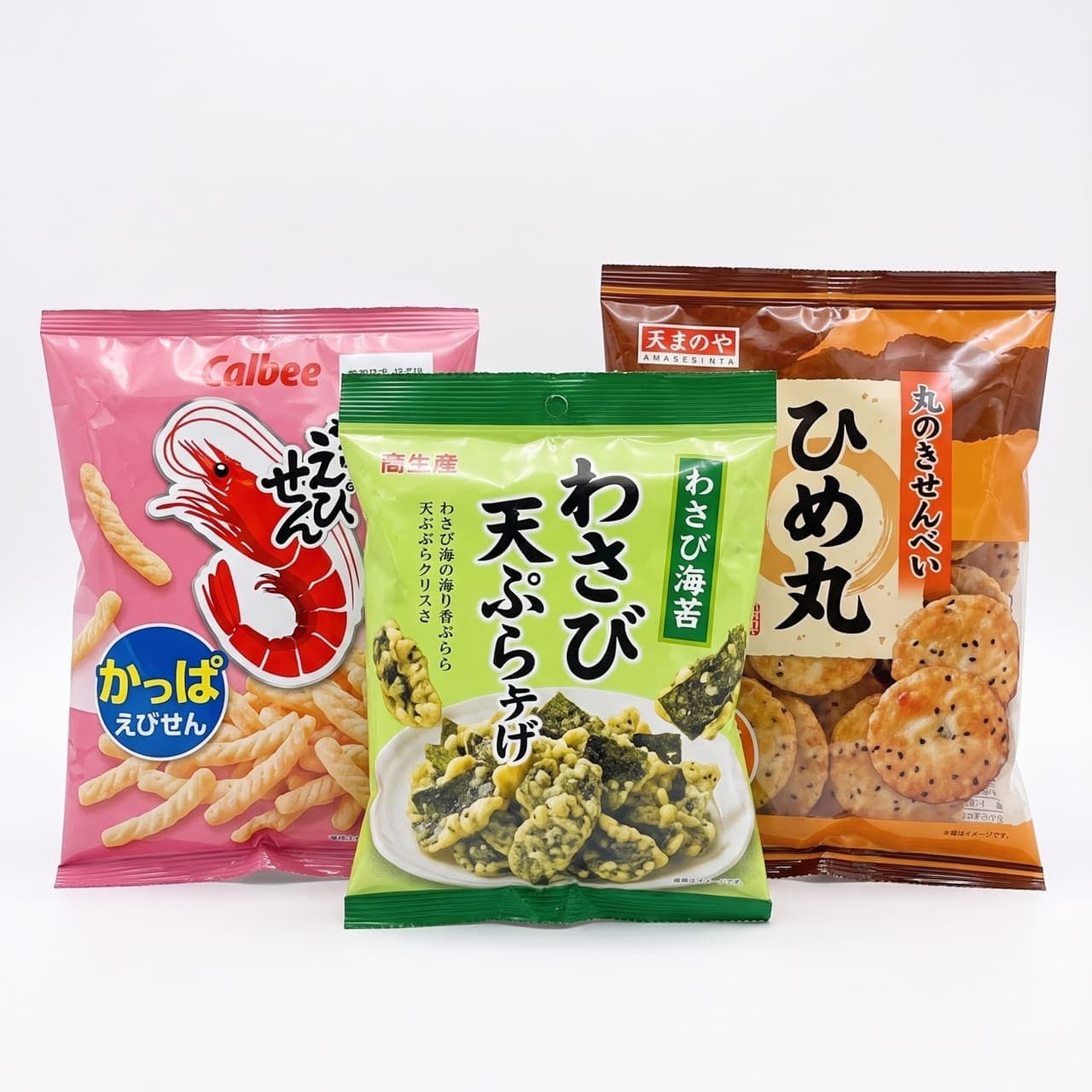 Japanese savory snacks: shrimp chips, wasabi seaweed tempura, and round senbei rice crackers on a white studio background